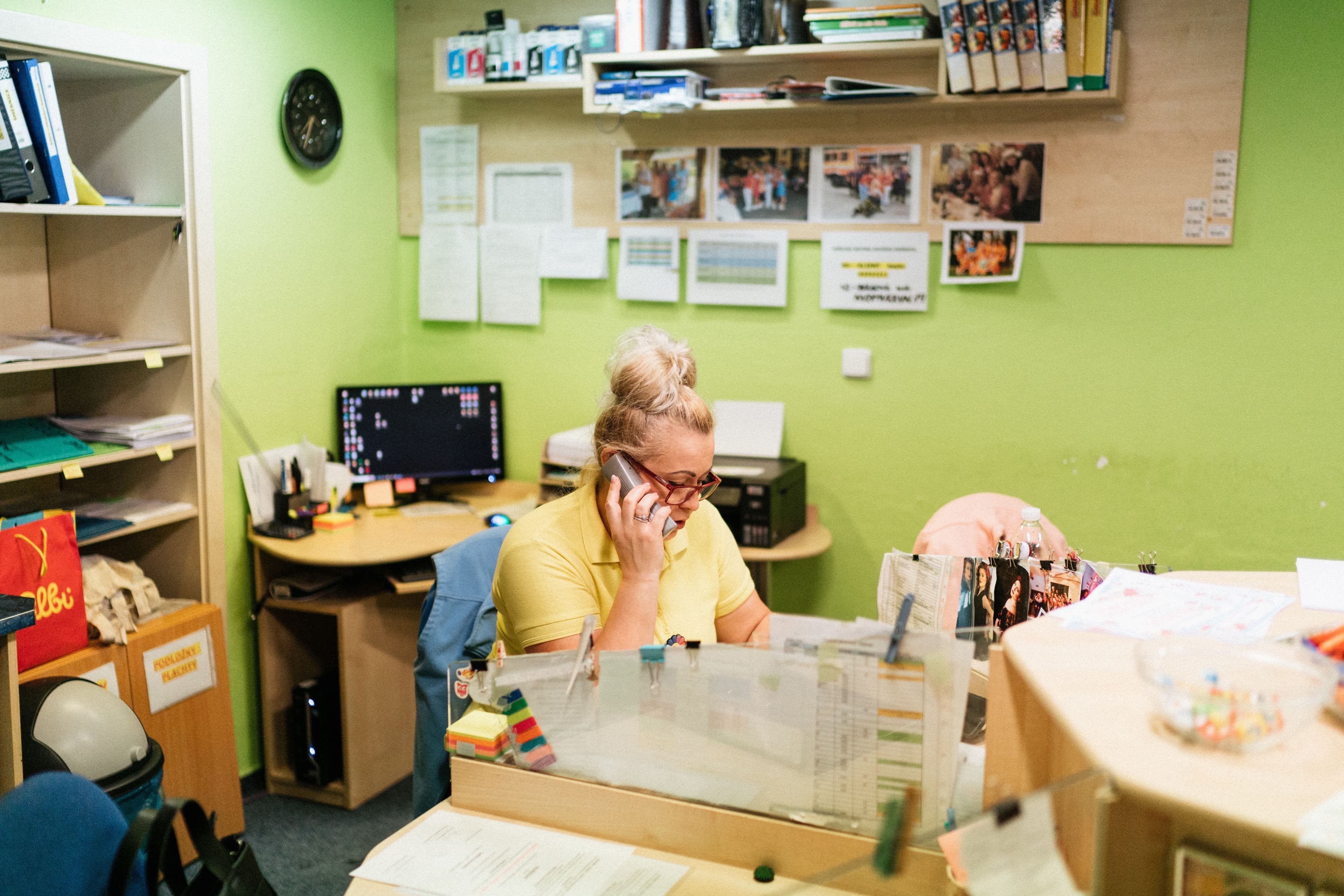 A receptionist taking a phone call behind a front desk.